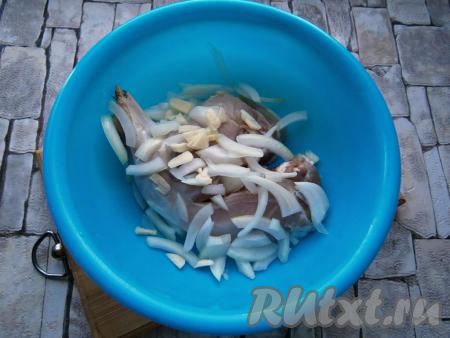 Лук и чеснок очистить. Поместить мясо в миску, добавить нарезанный произвольно репчатый лук и измельченный чеснок.