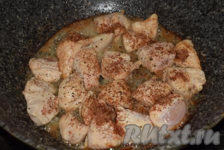 К обжаренным кусочкам куриного мяса добавим черный молотый перец и специи (я кладу молотый кориандр и паприку), жарим еще 5 минут, иногда помешивая.
