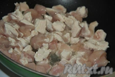 В сковороду налить немного растительного масла, выложить кусочки куриного филе и обжарить их в течение 5 минут на сильном огне, периодически помешивая.