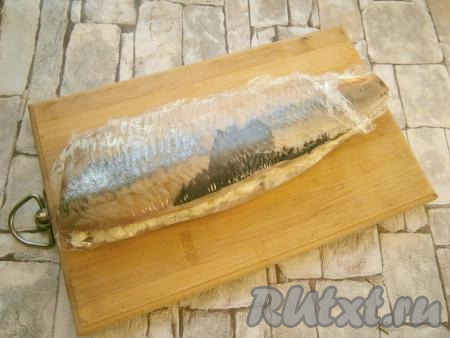 Сельдь, фаршированную сыром и маслом, плотно завернуть в пищевую пленку и поместить в морозилку на 1 час.