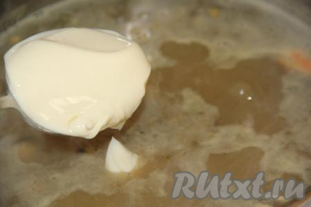 Добавить в суп плавленный сыр, перемешать. Проварить сырный суп с морепродуктами до полного растворения сыра (пару минут).