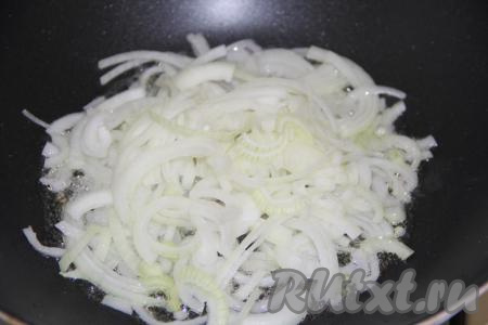 Очищенный репчатый лук, нарезав тонкими полукольцами, выложить в глубокую сковороду, разогретую с растительным маслом. Обжарить, помешивая, на среднем огне до золотистого цвета.