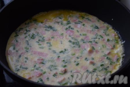 Сковороду разогреваем на медленном огне и добавляем сливочное масло. Выливаем омлетную массу в сковороду.