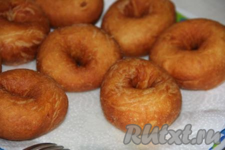 Готовые жареные пончики, аккуратно доставая из масла, сразу выкладывать на бумажные полотенца, чтобы убрать остатки масла.