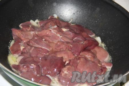 Куриную печень промыть под холодной водой, нарезать на крупные кусочки и выложить к луку, обжаренному с чесноком.