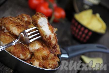 Подать вкусное, сочное куриное филе, покрытое аппетитной панировкой из чипсов, к столу с соусом и любым гарниром. Панировка хорошо держится на мясе и не опадает.