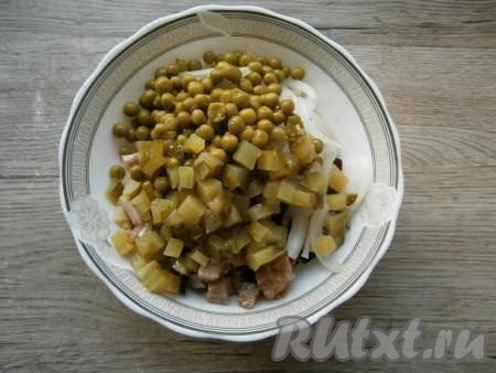 Выложить в салат нарезанный кубиками маринованный огурчик.