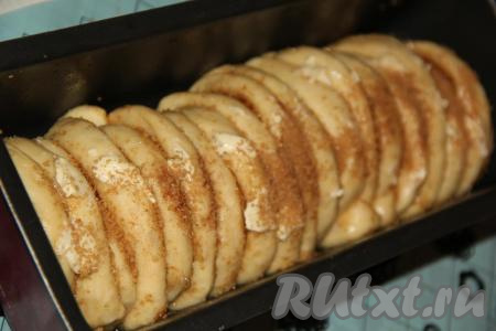 Форму для выпечки (у меня металлическая прямоугольная форма для кекса и хлеба) смазать растительным (или сливочным) маслом. Выложить наши "улиточки" в форму боковыми срезами друг к другу (как на фото). Выложить остатки масла на тесто и присыпать остатками пряной смеси.
