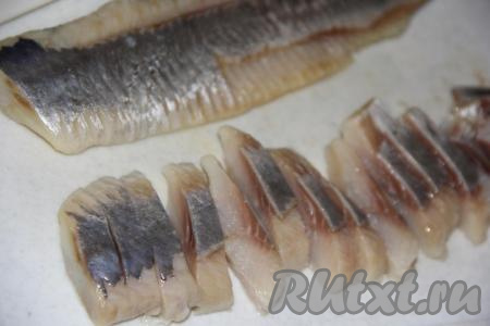 Если вы используете цельную солёную селёдку, предварительно тщательно очистите её от костей и кожи. Филе сельди нарезать крупными кусочками.