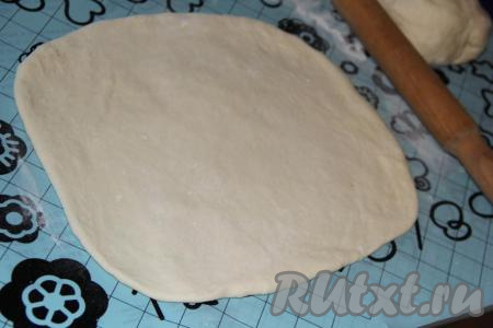 Стол (или силиконовый коврик) присыпать мукой, тесто раскатать в прямоугольный пласт. Раскатывать тонко тесто не нужно.