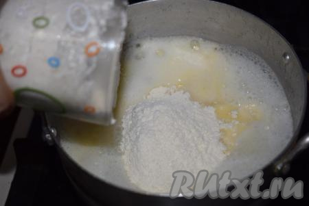 Уменьшаем огонь до минимума, в кипящую массу аккуратно добавляем всю муку.