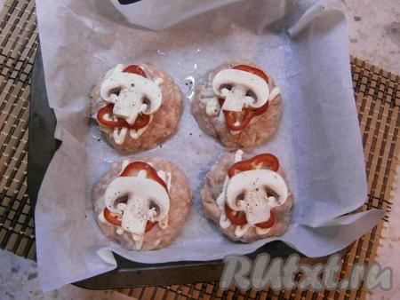 Шампиньоны нарезать на пластины. На каждую куриную котлету поверх колечка болгарского перца выложить пластину шампиньона, немного поперчить грибы.