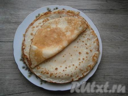 Смазывая немного сковороду растительным маслом (или другим маслом без резкого запаха, или жиром) и равномерно распределяя немного тесто на сковороде, на среднем огне пожарить тонкий блинчик до румяности с двух сторон. Таким образом приготовить все блины, складывая их стопочкой на тарелку (получится 10-13 блинчиков).