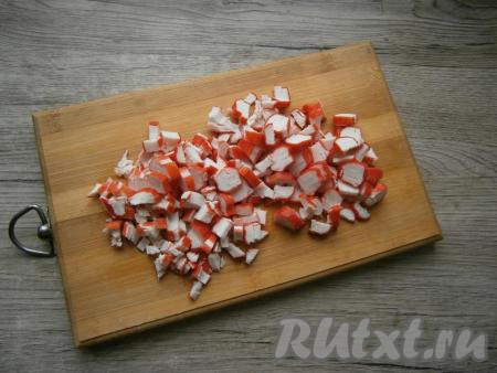 Крабовые палочки нарезать кусочками (одну палочку оставить для украшения, поместив ее в морозилку).