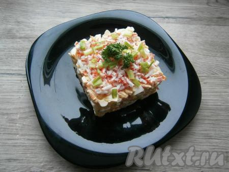 Из морозилки достать крабовую палочку, натереть ее на терке и посыпать салат сверху. Салат с крабовыми палочками и плавленным сыром также украсить измельчённым зелёным луком и веточкой петрушки.