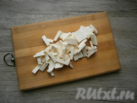 Ножом, смоченным в воде, нарезать плавленный сыр на брусочки.