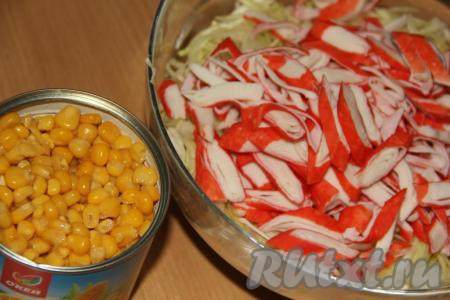 Крабовые палочки очистить от плёнки, крупно нарезать и выложить к капусте. С кукурузы слить жидкость.