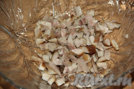 Отделить мякоть копчёной курицы от костей и нарезать на кусочки, можно порвать мясо на волокна.