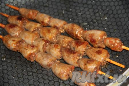 Выложить шпажки с куриными сердечками на разогретую сухую сковороду и обжаривать шашлыки с двух сторон на среднем огне.