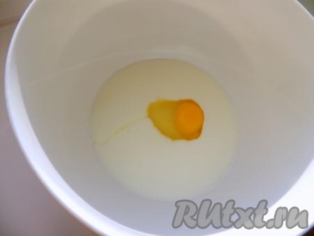 Кефир из холодильника влить в глубокую миску, вбить сырое яйцо и перемешать венчиком до однородности.