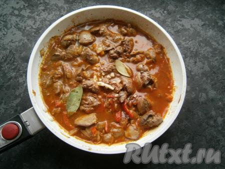 Дать жидкости закипеть, посолить по вкусу, огонь убавить до минимального, прикрыть сковороду крышкой и готовить подливу из куриной печени 15 минут, затем добавить в подливу лавровый лист и измельченный чеснок, продолжить тушить под крышкой ещё 5-7 минут.