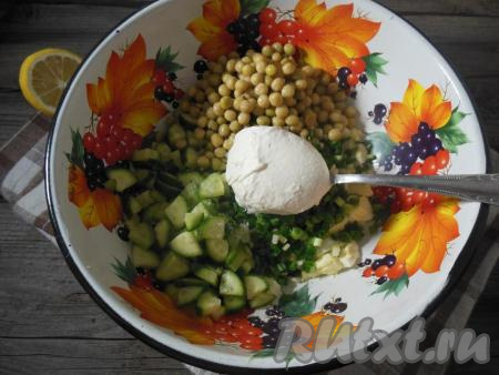 В глубокой миске смешайте нарезанные куриные яйца, зеленый лук, огурчики (немного огурцов оставьте для украшения), добавьте зеленый горошек без жидкости. Заправьте салат лимонным соком, щепоточкой соли, смесью молотых перцев и сметаной (или майонезом). 