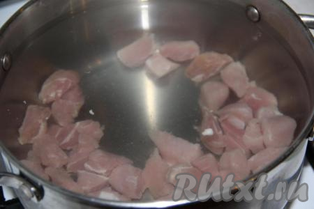 Свинину нарезать средними кубиками, выложить в кастрюлю и залить 2,8 литрами холодной воды. 