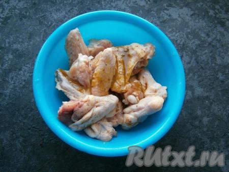 Приготовленным медовым соусом полить куриные крылышки.