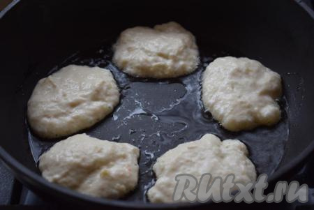 Разогреваем сковороду, добавляем, примерно, 5-7 столовых ложек растительного масла. В разогретое масло ложкой начинаем выкладывать тесто (примерно, по 1 столовой ложке теста на 1 оладушек). Жарим оладьи на среднем огне вначале с одной стороны до подрумянивания (2-3 минуты).