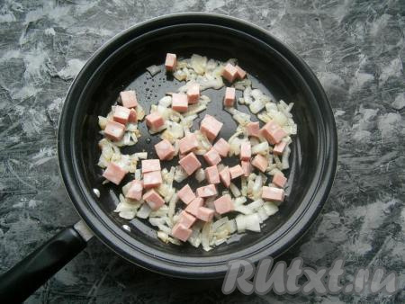 Обжарить лук на растительном масле, помешивая, до легкой золотистости. Добавить колбасу.