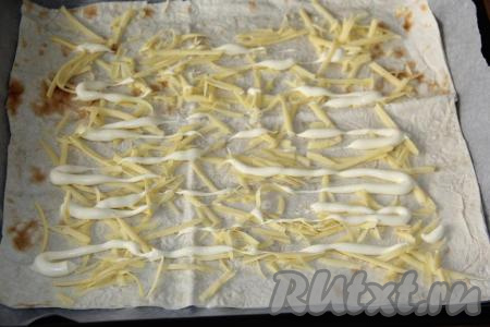 Лист лаваша присыпать небольшим количеством тёртого сыра и сделать решётку из майонеза.