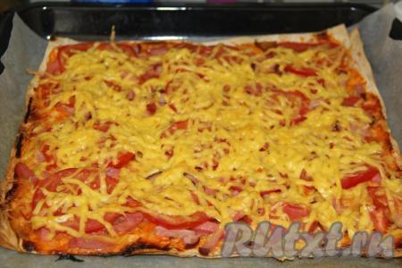 Начинку посыпать натёртым сыром и поставить противень в разогретую духовку. Выпекать "ленивую" пиццу из лаваша минут 15-20 при температуре 200 градусов.