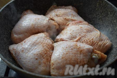 Для приготовления сочных куриных бедрышек возьмем сковороду с крышкой. Именно жарка под крышкой поможет сохранить мясу сочность, а затем, убрав крышку, мы сделаем на бедрышках аппетитнейшую корочку. В сковороде разогреем растительное масло и выложим куриные бедра.