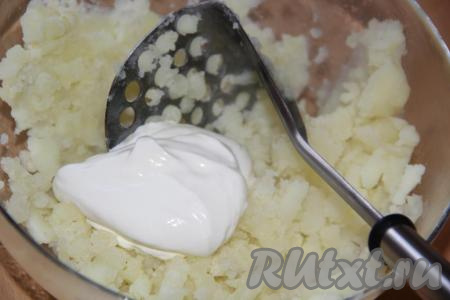 Слегка размять картофель толкушкой, а затем добавить сметану.