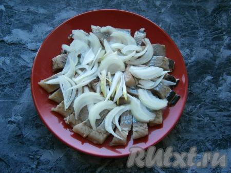 Очищенный лук нарезать тонкими полукольцами (или перьями), выложить поверх селедки.