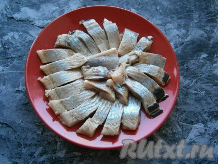 Филе сельди нарезать кусочками и выложить на тарелку.