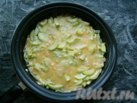 Жареные кабачки залить яйцами, посыпать измельченным чесноком, прикрыть сковороду крышкой, готовить на слабом огне 3-4 минуты (до готовности яиц).