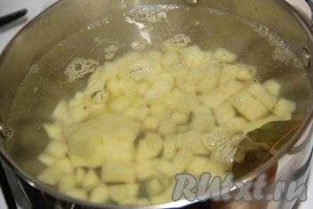 Картофель, лук и морковь очистить. Нарезать картошку на кубики. В кипящую воду выложить картофель и лавровый лист, варить 10 минут с момента закипания на небольшом огне.