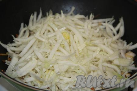Пекинскую капусту (я использовала нижнюю часть кочана) нарезать на тонкие полоски, добавить в сковороду. Тушить кусочки курицы с капустой на небольшом огне, помешивая, в течение 7 минут.