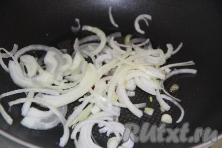 Лук очистить, нарезать тонкими полукольцами, выложить в сковороду с высокими бортиками (или сковороду вок) и добавить растительное масло. Обжарить лук на среднем огне, иногда помешивая, в течение 3 минут.