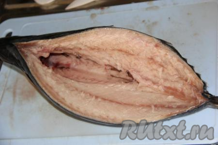 Тушку скумбрии вымыть (если рыба заморожена, заранее достаньте её из морозилки и разморозьте при комнатной температуре). Сделать глубокий разрез на рыбе со стороны спинки по краю основной кости. Затем перерезать основную кость у хвоста и головы, аккуратно вынуть кость вместе с внутренностями и чёрной пленочкой. Промыть рубку и обсушить бумажным полотенцем. У нас получилась вот такая лодочка для фаршировки.