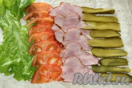 Ветчину (или другие мясные изделия) нарезать тонкими ломтиками. Огурчики нарезать тонкими слайсами. Рядом с помидорами выложить полоску из нарезанной ветчины, а затем полоску из огурцов (как на фото).