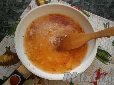 В сковороду выложить рис, влить 1,5 стакана горячей воды, после закипания уменьшить огонь.