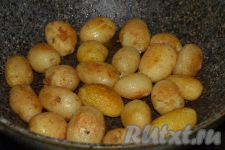 Далее разогреваем сковороду, кладем в нее сливочное масло, вливаем растительное масло, даем маслу разогреться. Вареную молодую картошку в кожуре выкладываем в сковороду и обжариваем со всех сторон на небольшом огне, примерно, 10-15 минут (до подрумянивания клубней). При необходимости, можно подсолить и поперчить картофель уже в сковороде.