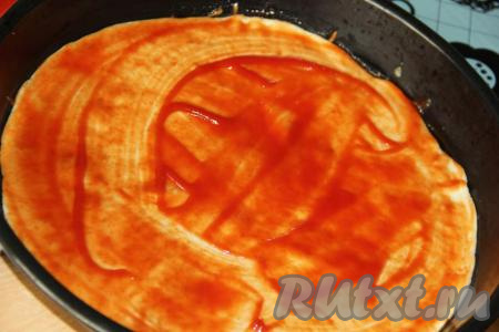 Смазать тесто томатным соусом.