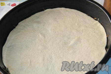 Одну часть теста слегка обмять и раскатать в круг. Выложить раскатанное тесто на противень, смазанный растительным маслом.