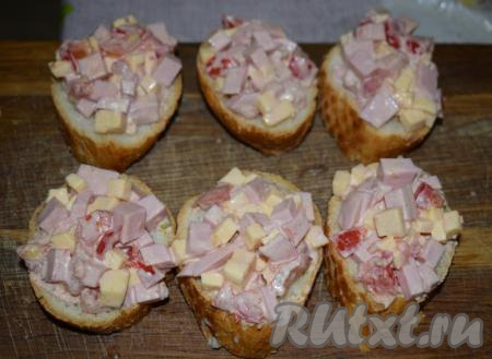 На кусочки багета выкладываем по 1 столовой ложке начинки с горкой.