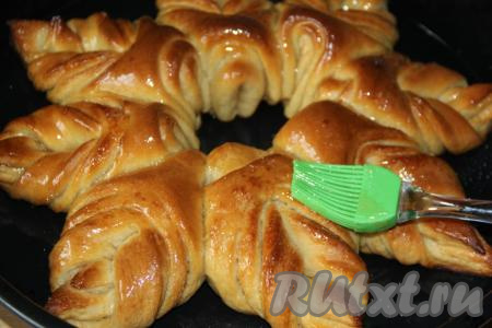 Выпекать красивый дрожжевой пирог из булочек в разогретой духовке, примерно, 30 минут при температуре 180-200 градусов. Горячий пирог достать из духовки и сразу смазать мёдом с помощью силиконовой кисти. Слегка остудить выпечку, а затем переложить на тарелку.