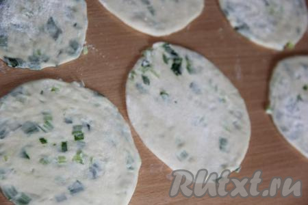 Припылить стол мукой и раскатать каждую часть рулета в круглую лепёшку (у нас получится 10-12 лепёшек с луком).