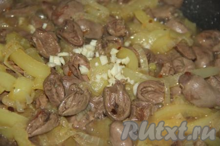 По прошествии времени к куриным сердечкам с овощами добавить мелко нарезанный зубчик чеснока, перемешать. Выключить огонь и дать блюду  "отдохнуть" под крышкой минут 10.